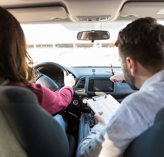 Fahrlehrer im Auto mit Fahrschülerin