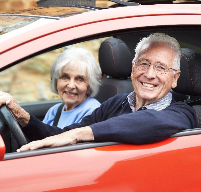 Lachendes älteres Paar im Auto